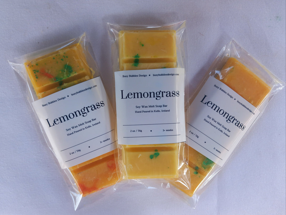 Three packages of lemongrass snap bars on a white background